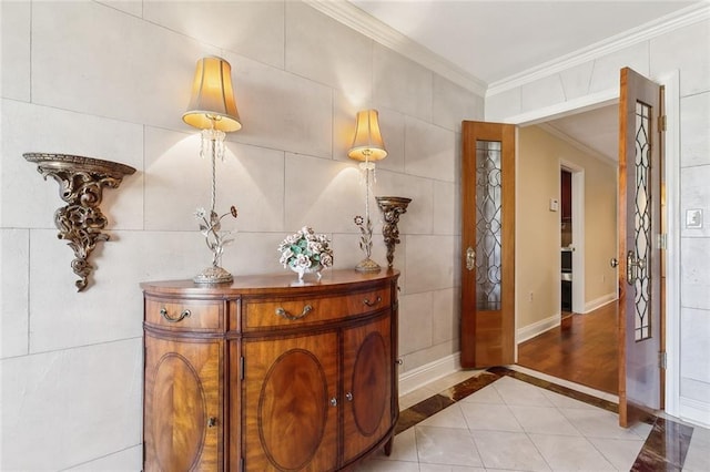 tiled entryway featuring baseboards, tile walls, and ornamental molding