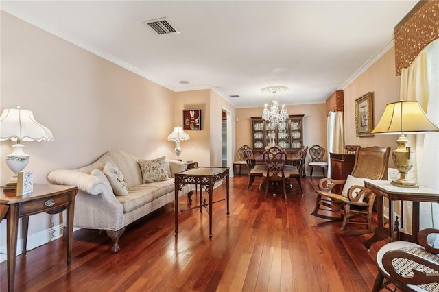 living area with visible vents, crown molding, baseboards, an inviting chandelier, and hardwood / wood-style flooring