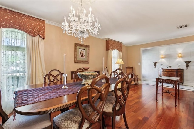 dining space with visible vents, plenty of natural light, wood finished floors, and crown molding