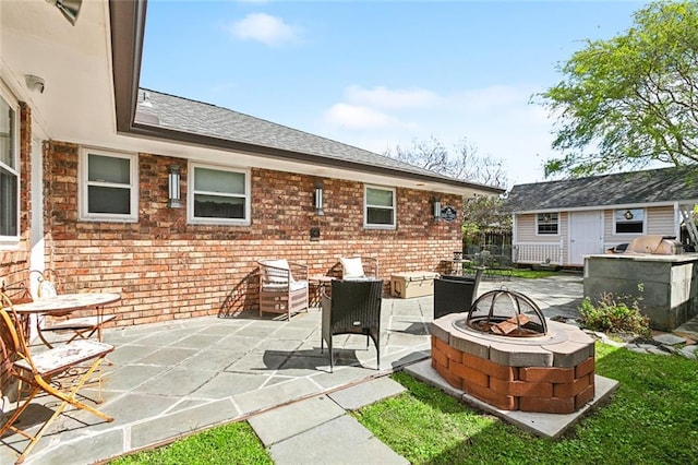 view of patio featuring an outbuilding and a fire pit