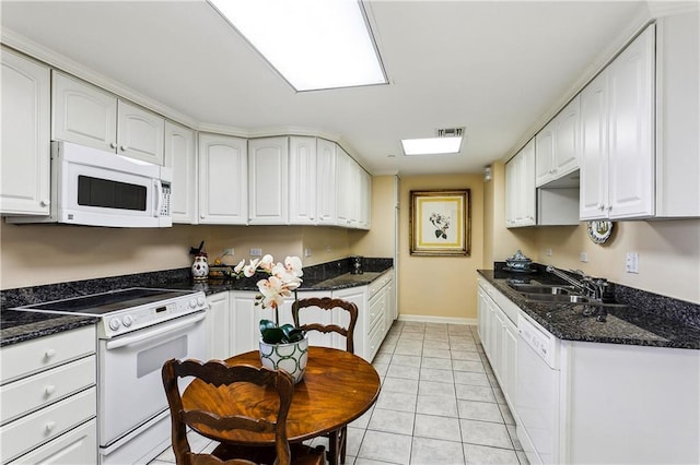 kitchen with white appliances, visible vents, light tile patterned flooring, a sink, and white cabinets