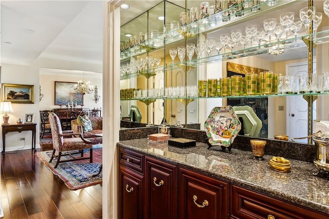 bar featuring a notable chandelier and wood finished floors