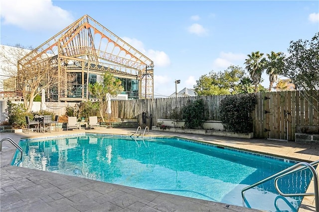 view of pool with a fenced in pool, a patio area, and fence