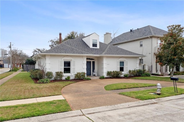 4533 N Turnbull Dr, Metairie, LA 70002 - view of front facade featuring brick siding, curved driveway, and a front yard