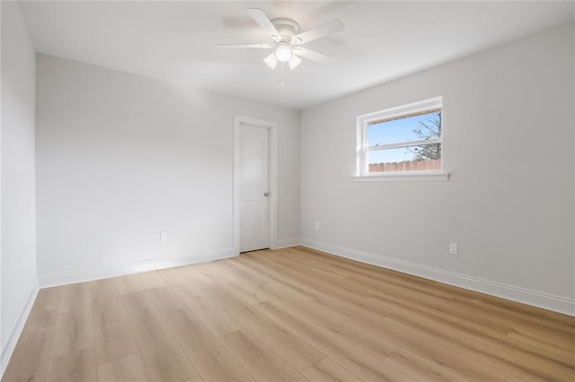 spare room with light wood-style floors, baseboards, and ceiling fan