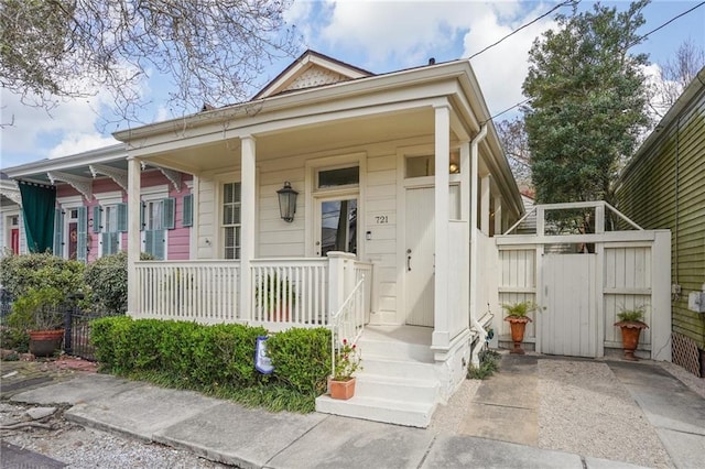 view of front of property featuring covered porch and fence