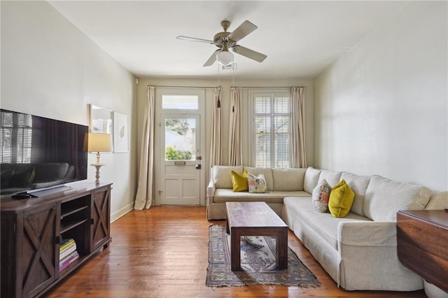 living room featuring a ceiling fan, wood finished floors, and baseboards