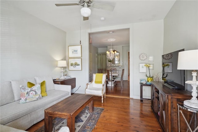 living room with ceiling fan with notable chandelier and wood finished floors