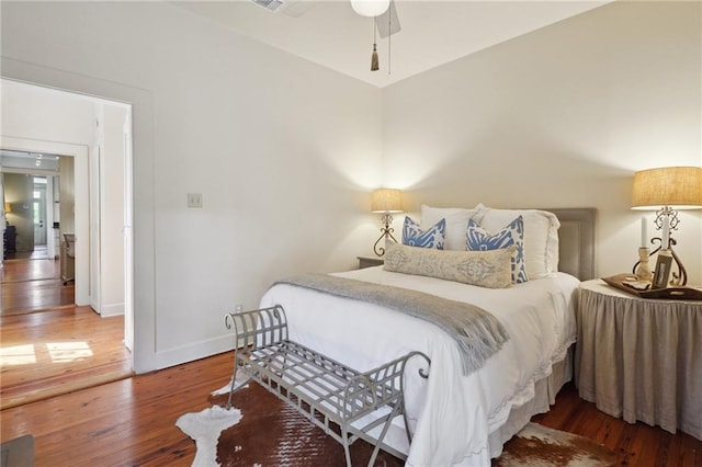 bedroom featuring a ceiling fan, visible vents, wood finished floors, and baseboards