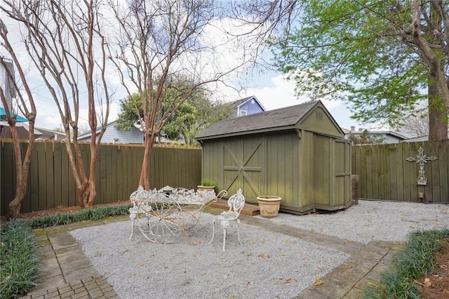 view of patio / terrace featuring a fenced backyard, a shed, outdoor dining space, and an outdoor structure