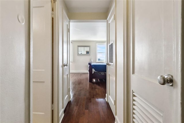 hall with dark wood-type flooring and baseboards