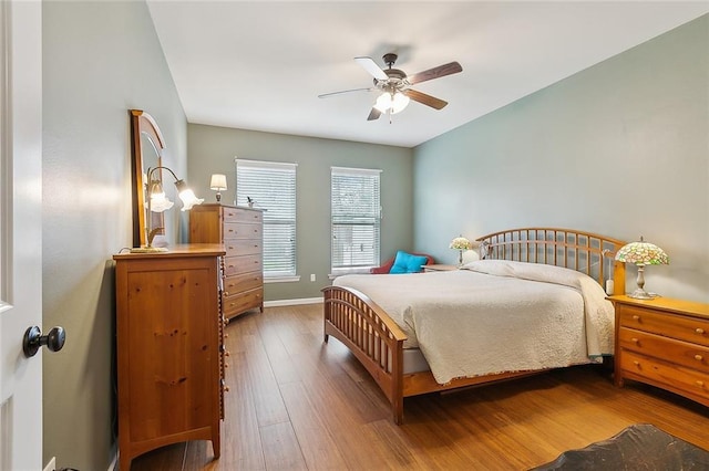 bedroom with a ceiling fan, baseboards, and hardwood / wood-style floors