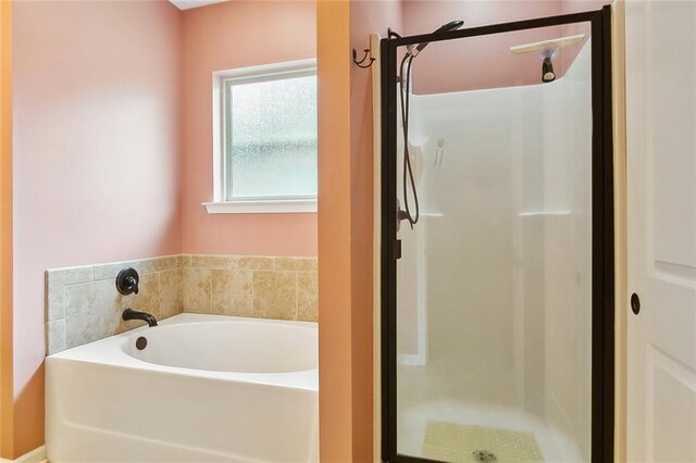 full bathroom featuring a garden tub and a stall shower