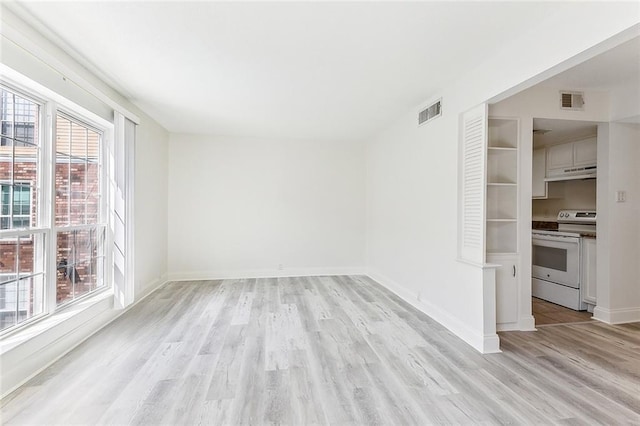 unfurnished room featuring visible vents, baseboards, and light wood-style floors