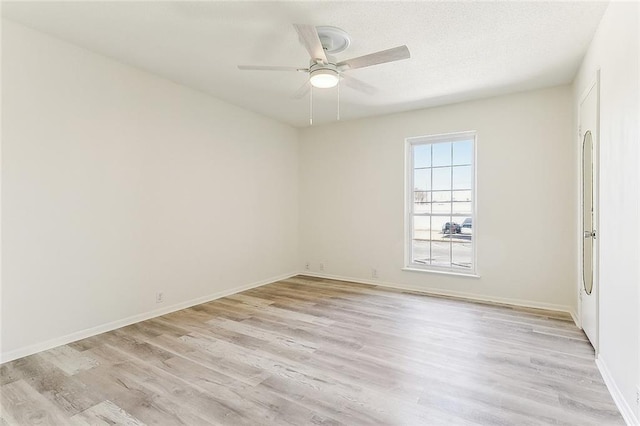 unfurnished room with a textured ceiling, light wood-style floors, baseboards, and ceiling fan