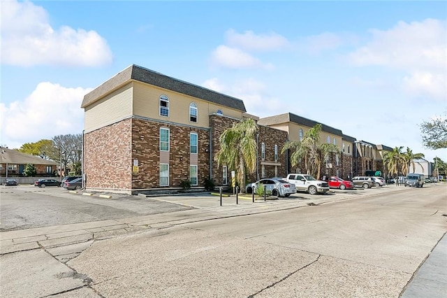 view of building exterior featuring uncovered parking and a residential view