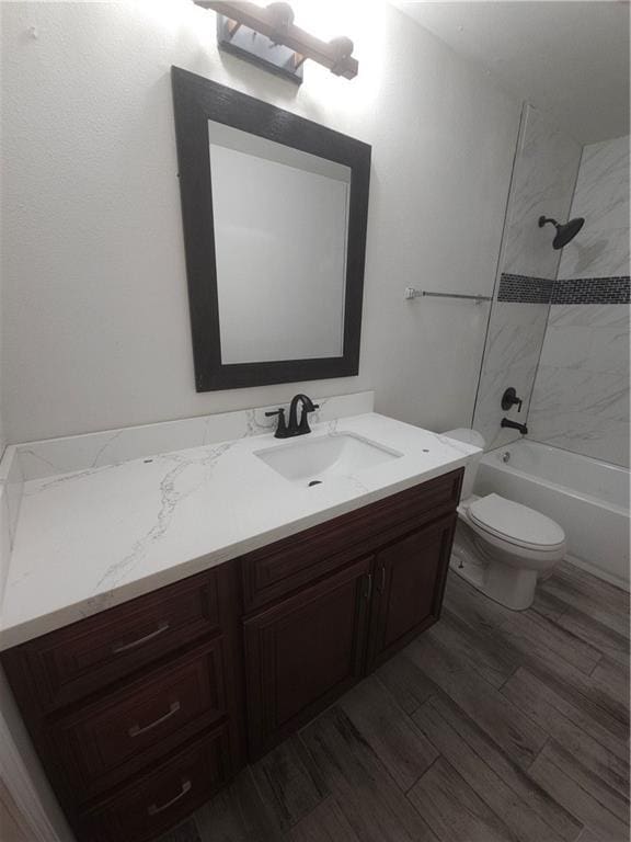 full bathroom featuring tub / shower combination, toilet, vanity, and wood finished floors