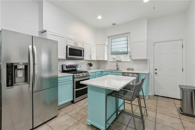 kitchen featuring a sink, white cabinetry, stainless steel appliances, light tile patterned floors, and decorative backsplash