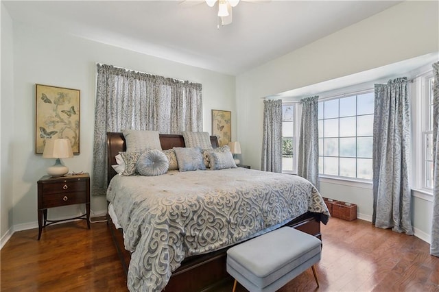 bedroom with a ceiling fan, baseboards, and dark wood-style flooring