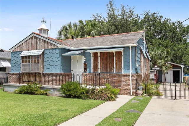 bungalow featuring concrete driveway, a front lawn, and fence