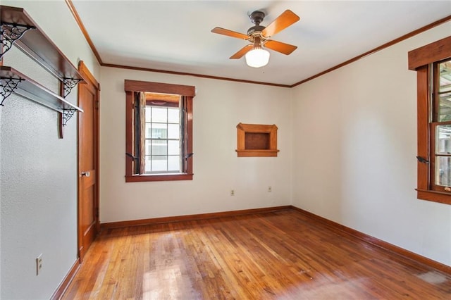 unfurnished bedroom with a ceiling fan, baseboards, light wood-type flooring, and ornamental molding