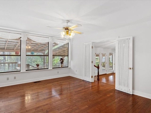 spare room with visible vents, baseboards, a ceiling fan, and hardwood / wood-style flooring