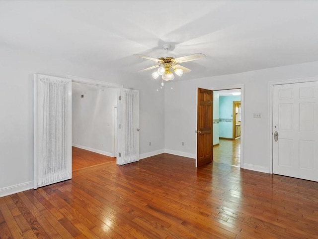 spare room featuring baseboards, a ceiling fan, and hardwood / wood-style floors