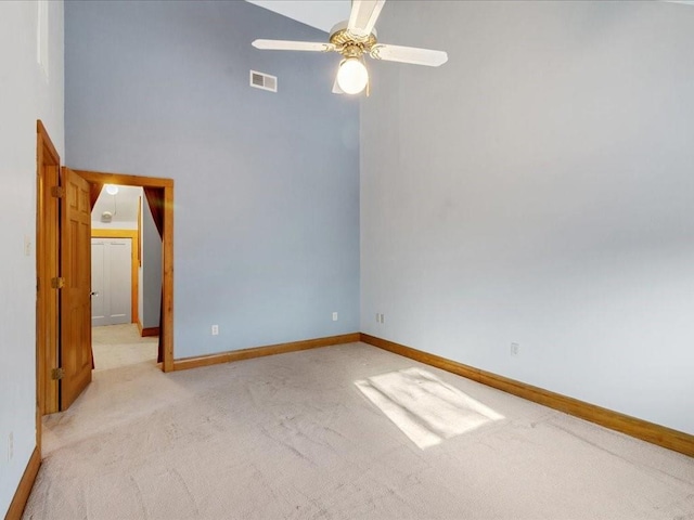 spare room featuring light carpet, visible vents, baseboards, and ceiling fan