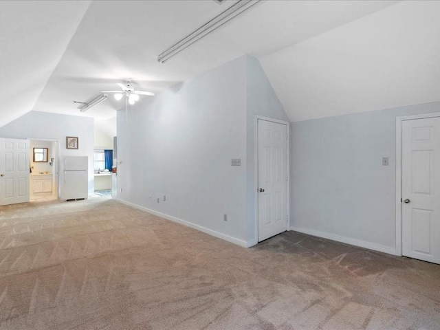 additional living space featuring baseboards, light colored carpet, ceiling fan, and vaulted ceiling