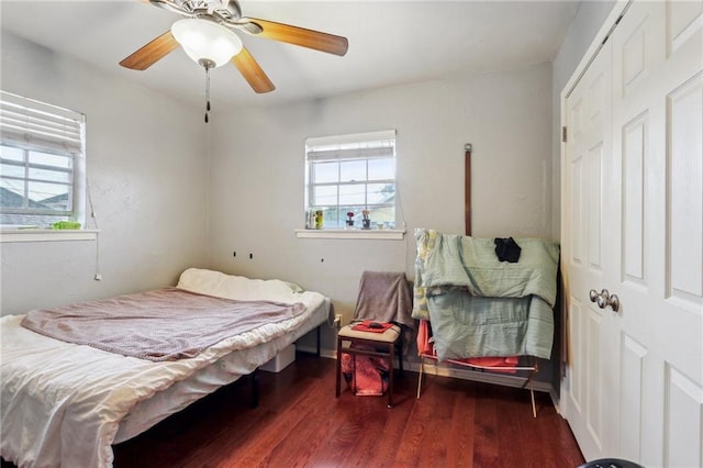 bedroom featuring multiple windows, wood finished floors, and a ceiling fan