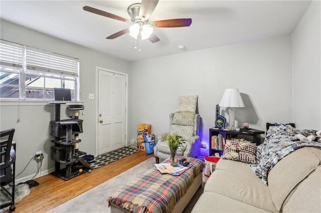 living area with wood finished floors and a ceiling fan