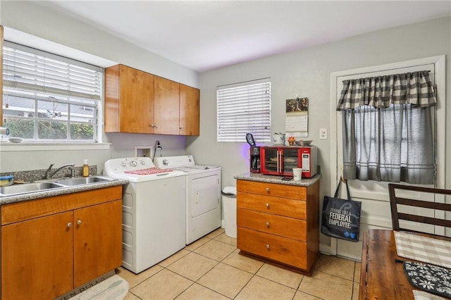 washroom featuring washing machine and dryer, cabinet space, and light tile patterned floors
