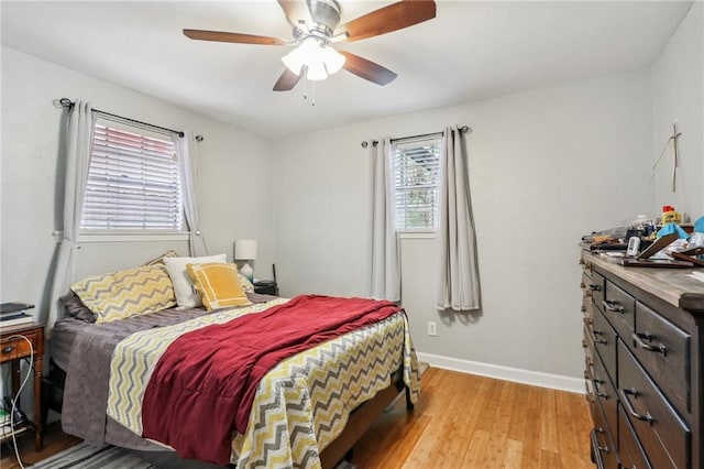 bedroom with light wood finished floors, baseboards, and ceiling fan