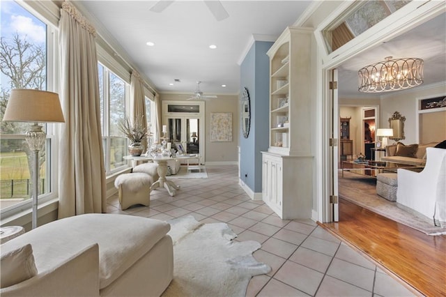 interior space featuring light tile patterned floors, ceiling fan with notable chandelier, recessed lighting, and ornamental molding