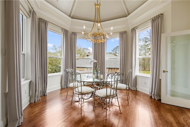 dining area featuring a notable chandelier, wood finished floors, plenty of natural light, and ornamental molding