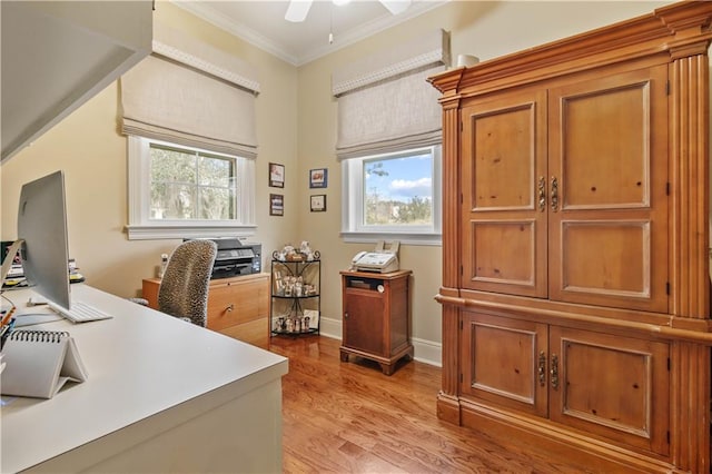 office area featuring baseboards, light wood-type flooring, a ceiling fan, and ornamental molding