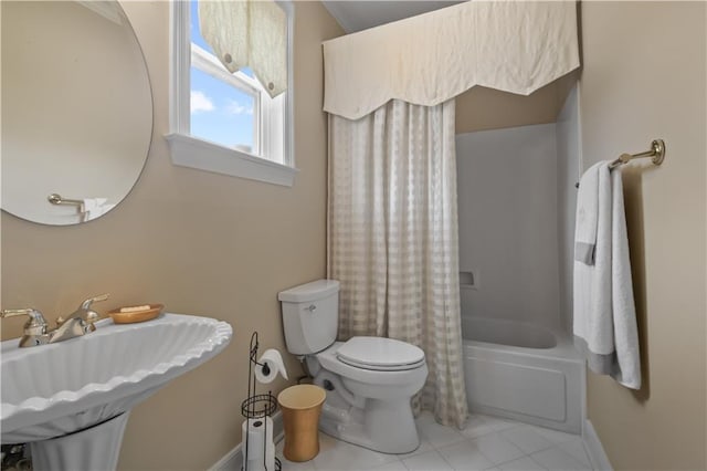 full bathroom featuring toilet, shower / bath combo with shower curtain, baseboards, and a sink