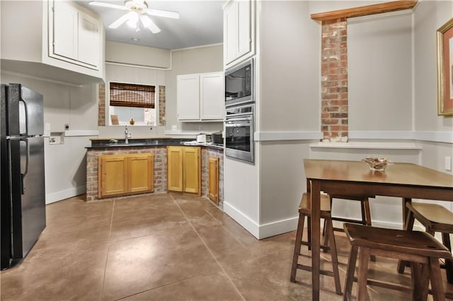 kitchen with oven, baseboards, ceiling fan, built in microwave, and freestanding refrigerator