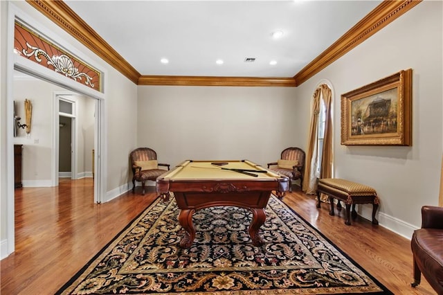 game room with visible vents, baseboards, wood finished floors, and ornamental molding