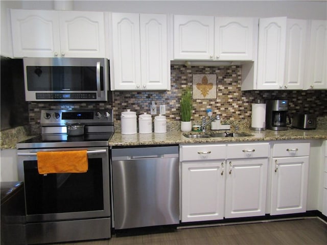 kitchen featuring appliances with stainless steel finishes, white cabinetry, and a sink