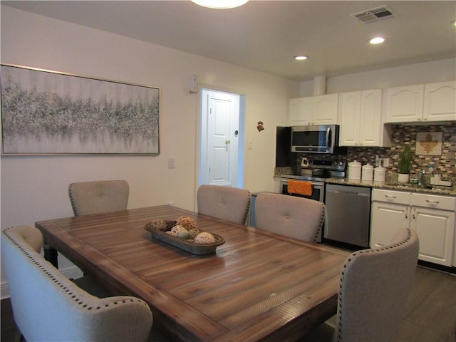 dining area with dark wood finished floors, visible vents, and recessed lighting