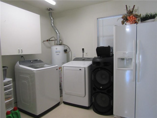 clothes washing area featuring washing machine and clothes dryer, cabinet space, and gas water heater