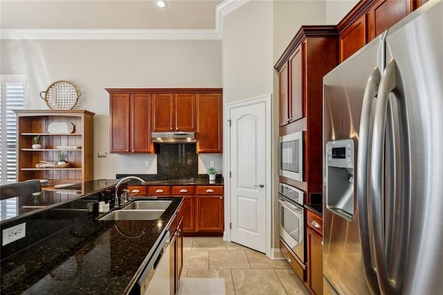 kitchen featuring tasteful backsplash, under cabinet range hood, ornamental molding, appliances with stainless steel finishes, and a sink