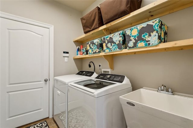 laundry area featuring laundry area, washing machine and dryer, and a sink