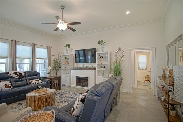 living area featuring baseboards, a fireplace, ornamental molding, and a ceiling fan