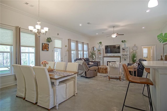 dining area featuring visible vents, plenty of natural light, concrete floors, and ceiling fan with notable chandelier