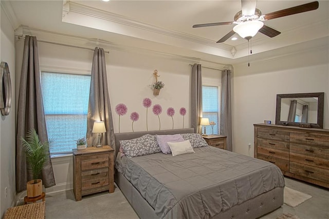 carpeted bedroom featuring multiple windows, crown molding, and a tray ceiling