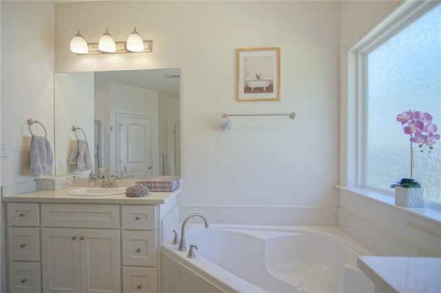 bathroom with vanity and a bath