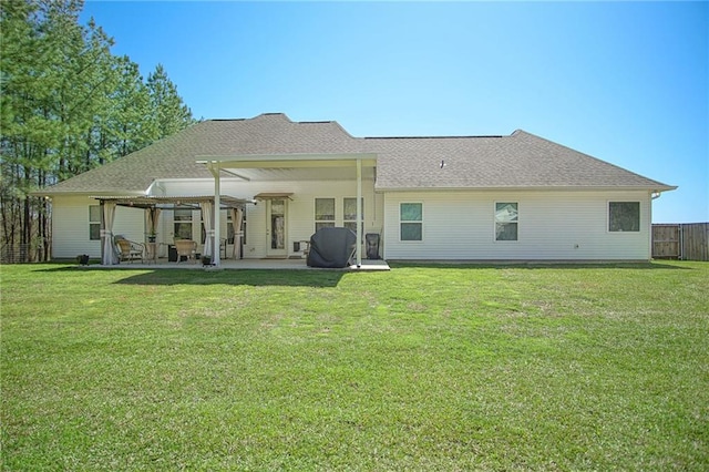 rear view of property with a patio, a yard, and fence