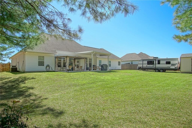 rear view of property featuring a yard, a patio, and fence